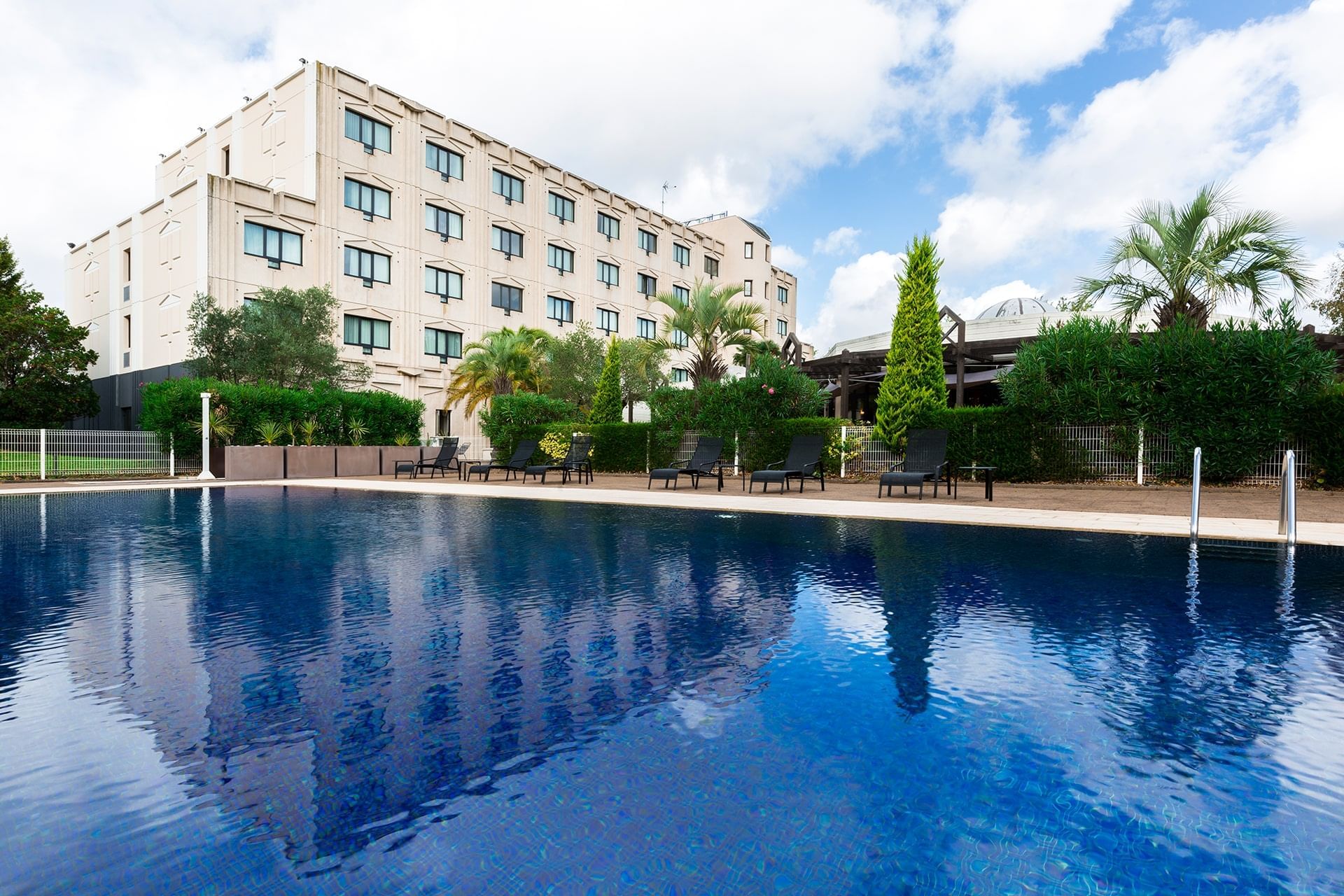 Lounges by the outdoor pool area at Oceania Nantes Aéroport