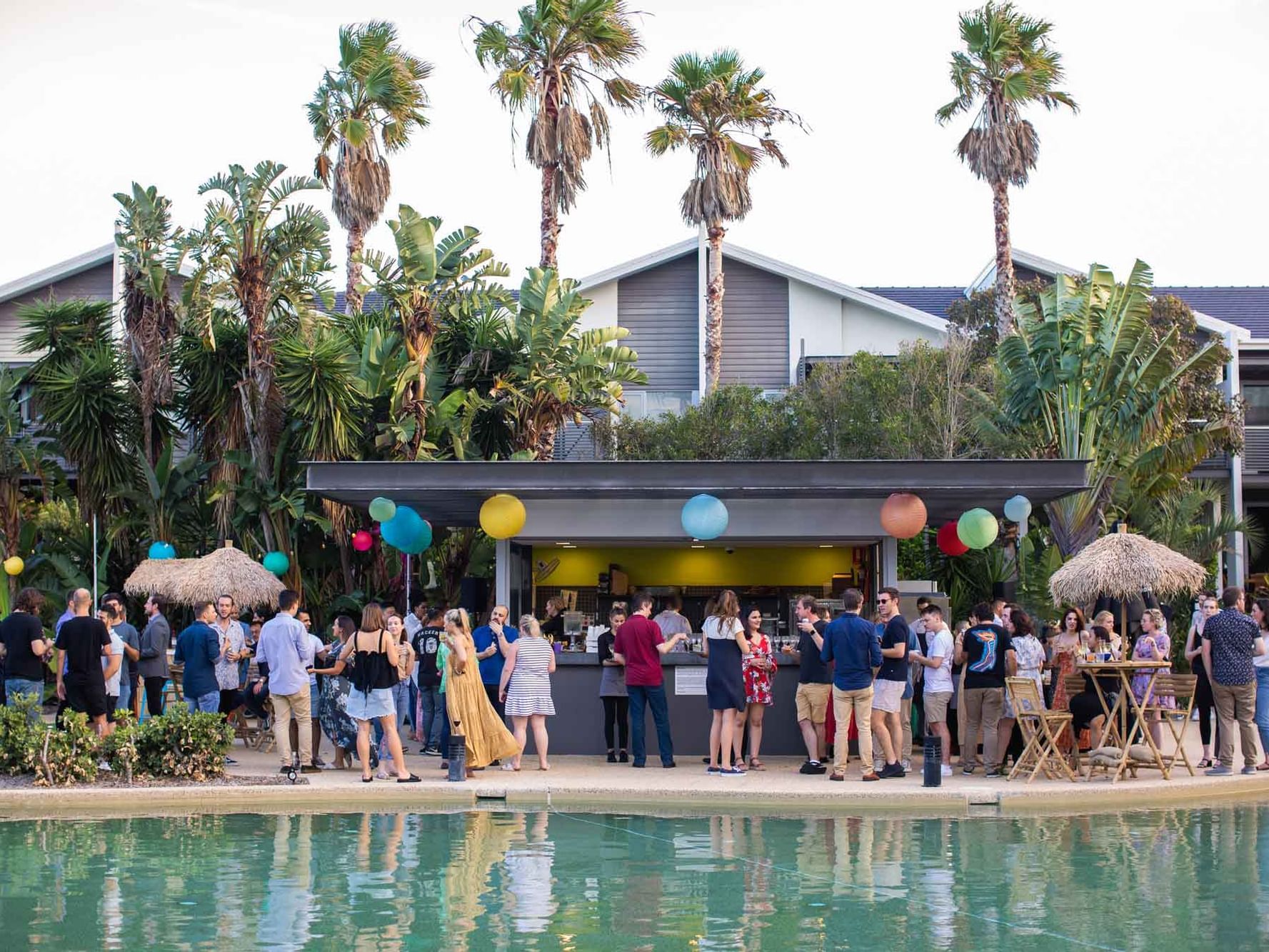 People gathered in the open bar by the pool area at Pullman Magenta Shores