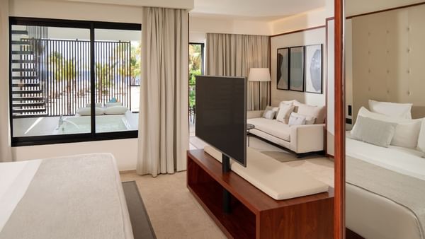 Bed and TV with separate living area in Luna Suite at Live Aqua Resorts