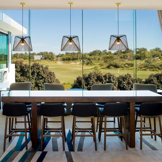 High Table arranged by the glass wall in Shallows Bar at Pullman Magenta Shores Resort