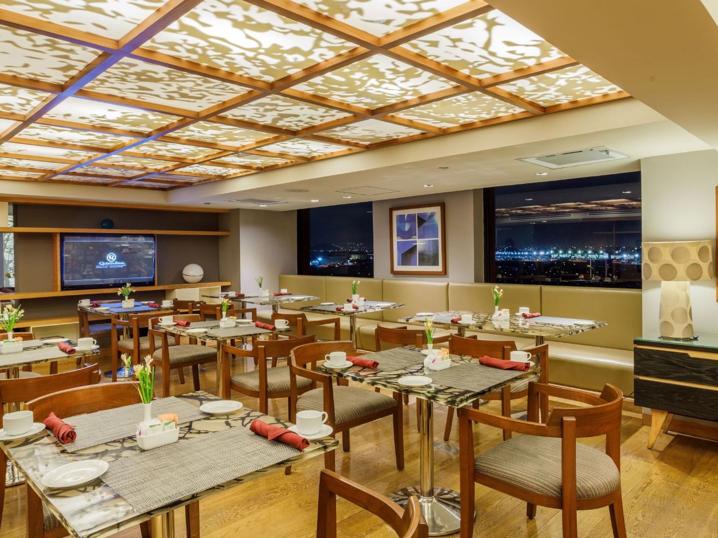 Comedor elegante con vista nocturna de la ciudad en Camino Real Aeropuerto México en Ciudad de México