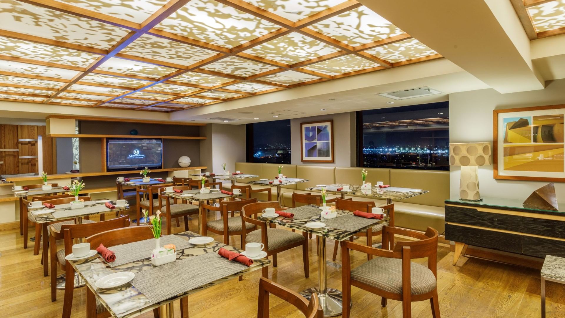 Comedor elegante con vista nocturna de la ciudad en Camino Real Aeropuerto México en Ciudad de México
