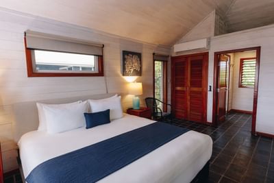 One Bedroom Oceanfront Villa with a large bed and dark tiled floors at Barefoot Cay Resort & Marina