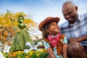 A kid with father seated in the garden at the EPCOT International Flower & Garden Festival