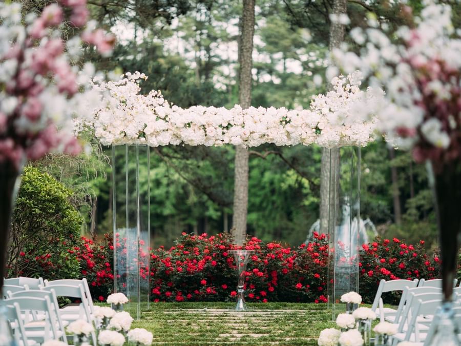 Outdoor wedding arch featuring white flowers in the Wedding Lawn at Umstead Hotel and Spa