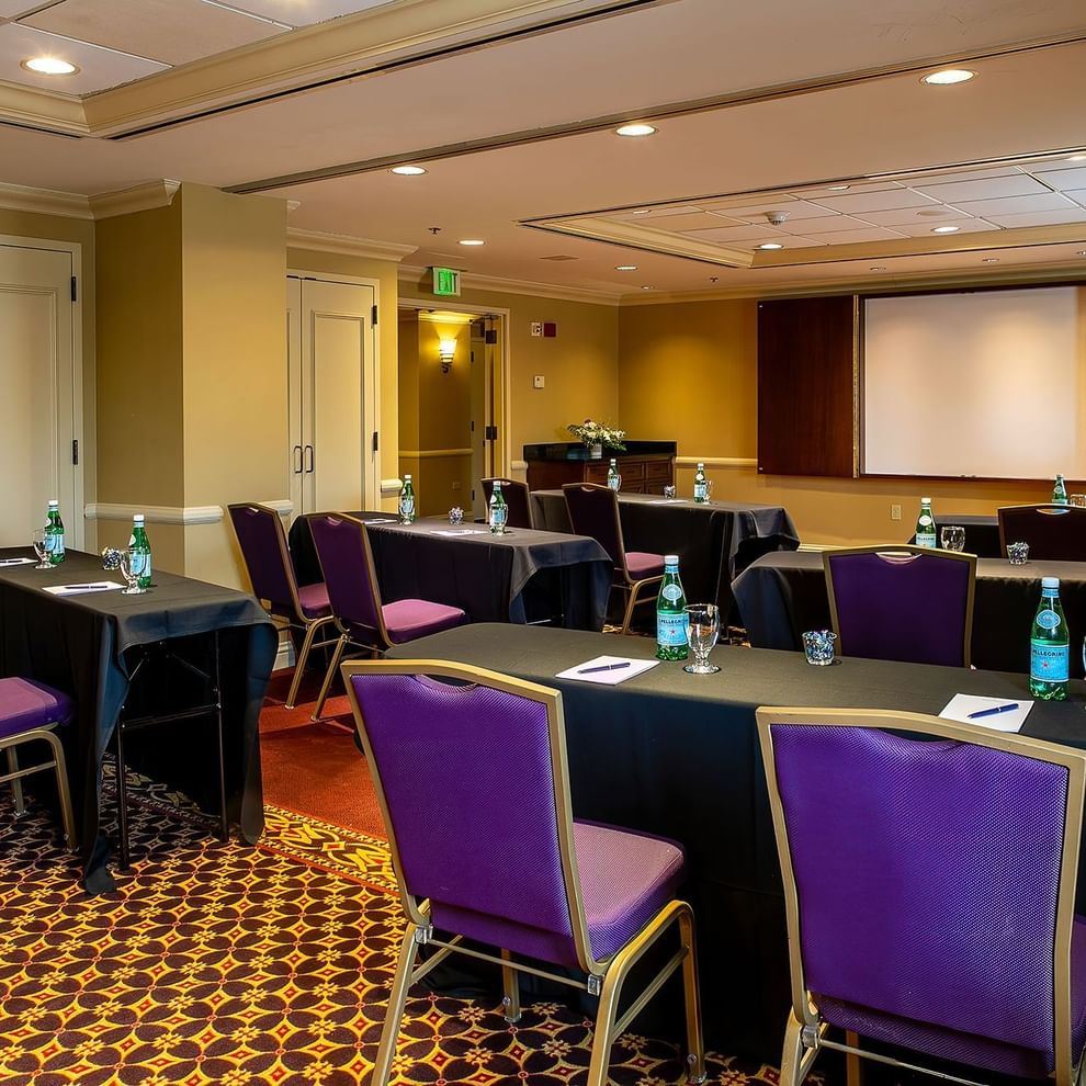 a conference room with round tables and purple chairs