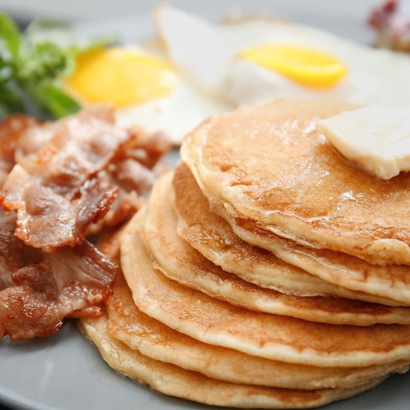 Close-up of breakfast pancakes and bacon at Warwick San Francisco