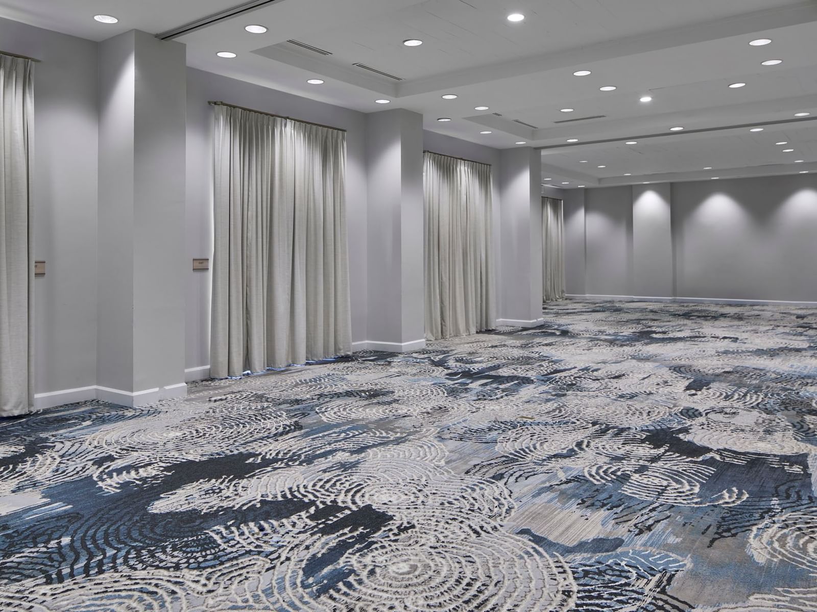 Sabal One at the Inn at Celebration, with swirling blue carpet and tall white ceiling-to-floor drapes