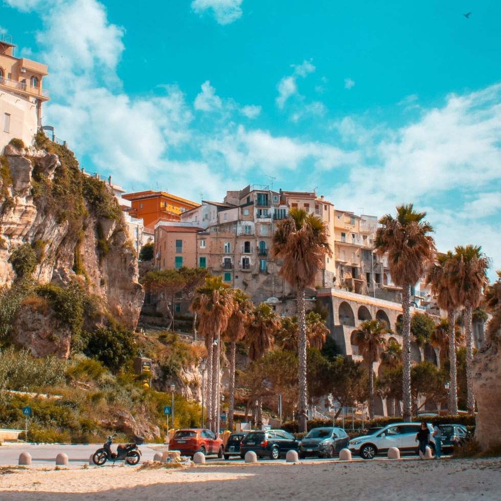 Pastel buildings with a cliff and palm trees in Catanzaro near Falkensteiner Club Funimation Garden Calabria