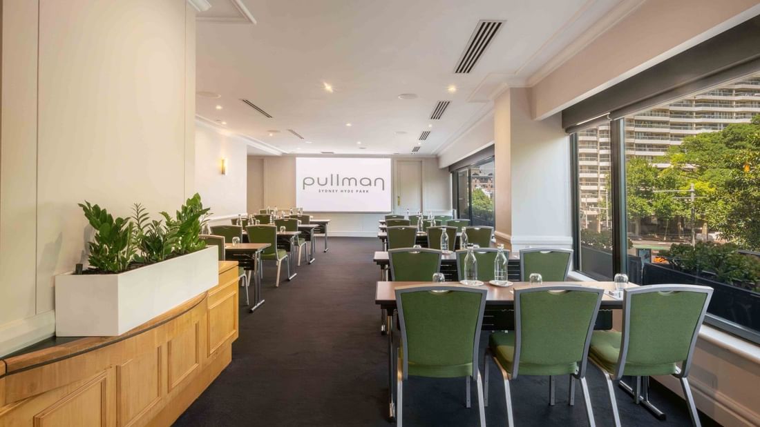 Classroom table set-up with projector screen in Parkview Room at Pullman Sydney Hyde Park