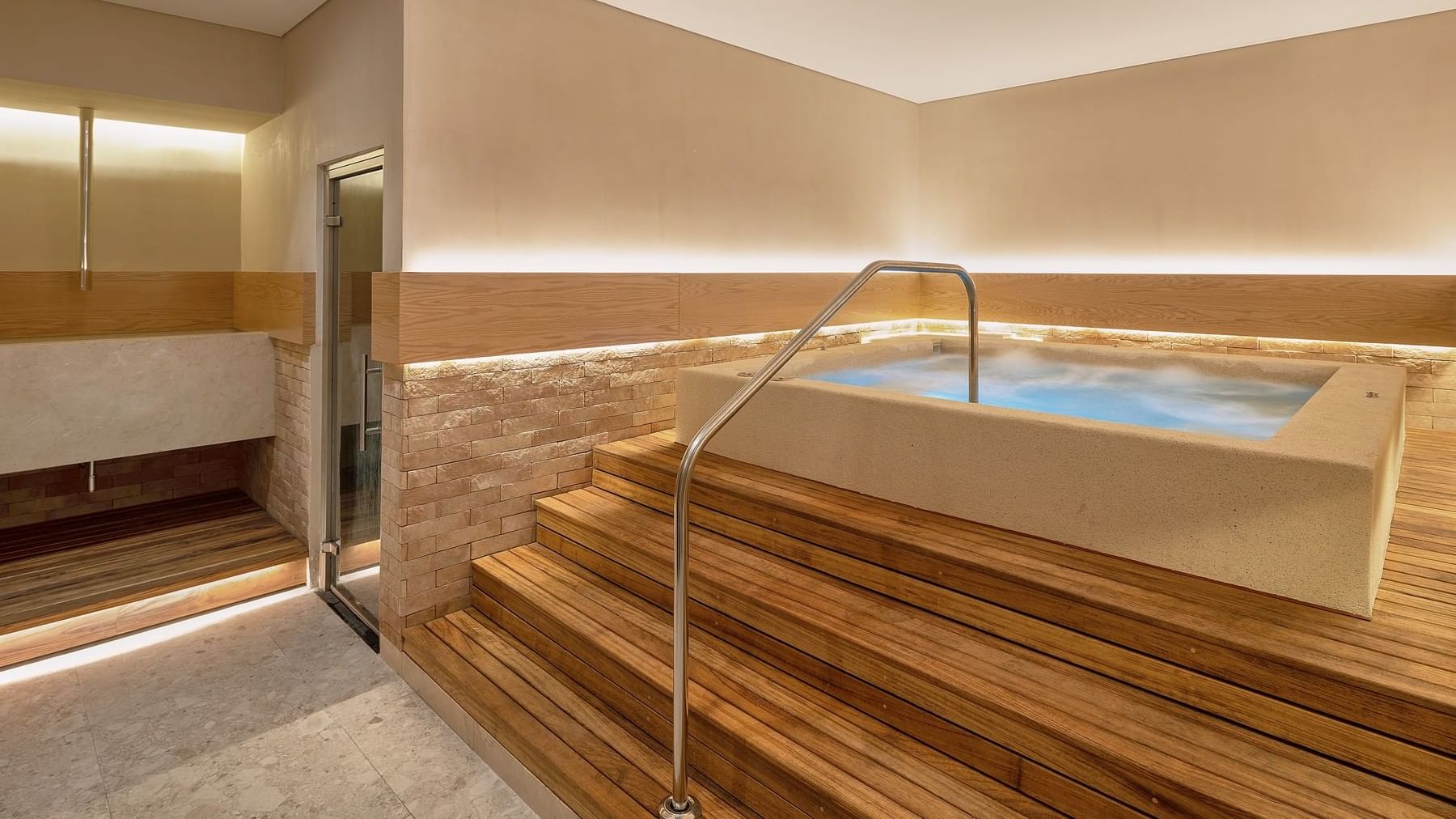 Spa room featuring a hot tub surrounded by wooden steps at Grand Fiesta Americana