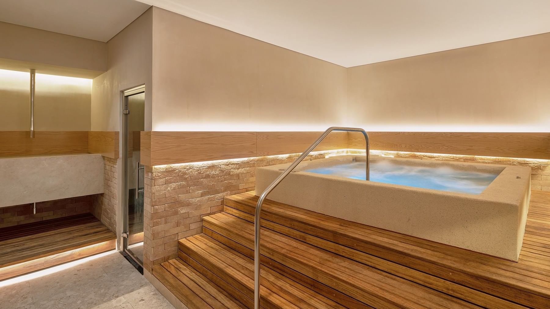 Spa room featuring a hot tub surrounded by wooden steps at Grand Fiesta Americana