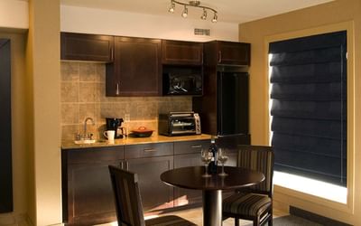 Interior of the kitchen area with a dining table for 2 in Studio King Riverview at Franklin Suite Hotel