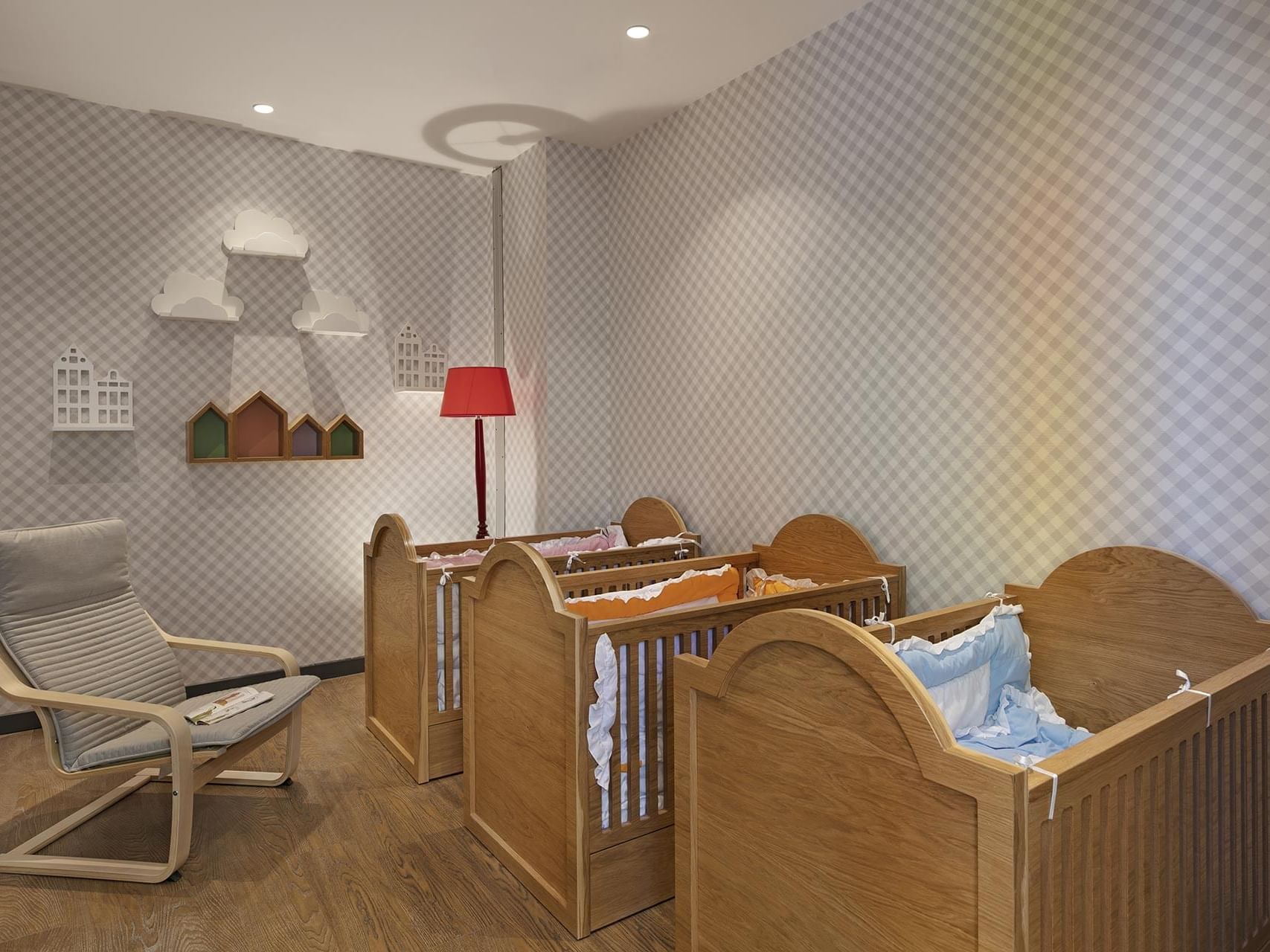 Cozy nursery room with wooden cribs, and a rocking chair at Titanic Deluxe Golf Belek