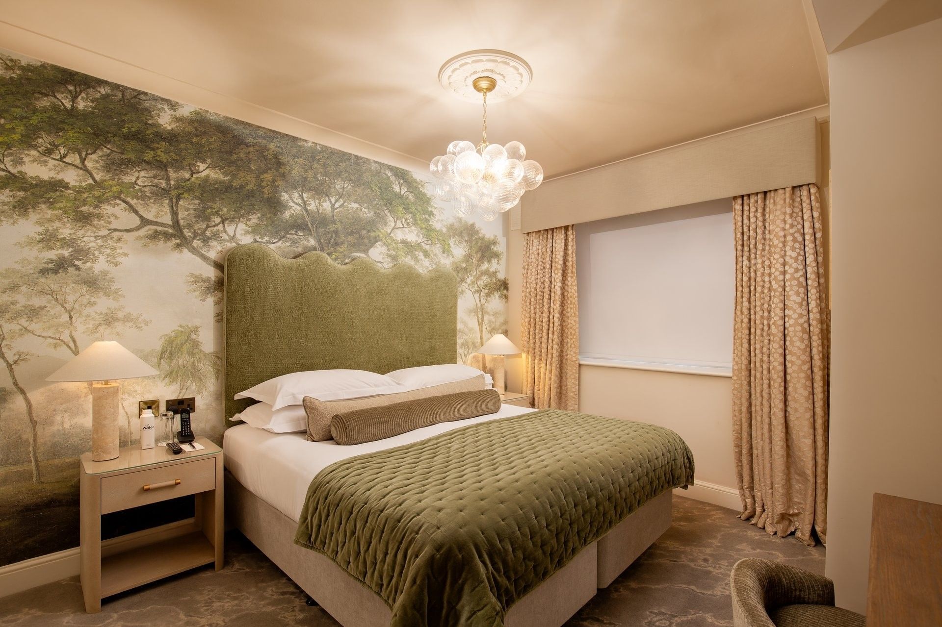 Bed with side table near window in Two Bedroom Apartment at The Capital Hotel, Apartments and Townhouse