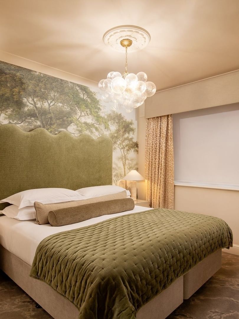 Elegant bedroom with a large bed, nightstand, and scenic wallpaper at The Capital Hotel, Apartments & Townhouse