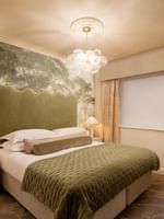 Elegant bedroom with a large bed, nightstand, and scenic wallpaper at The Capital Hotel, Apartments & Townhouse