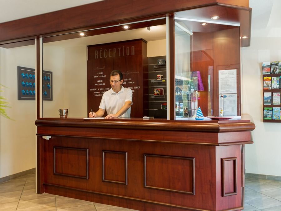 A receptionist at the reception desk in Hotel Les Oceanes