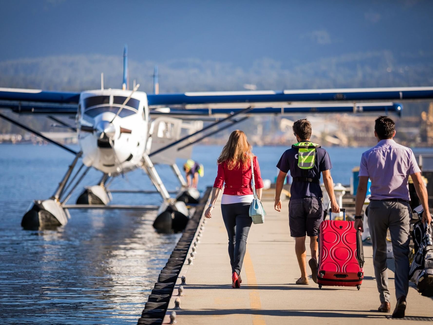 family walking towards their harbour air seaplane parked by the dock