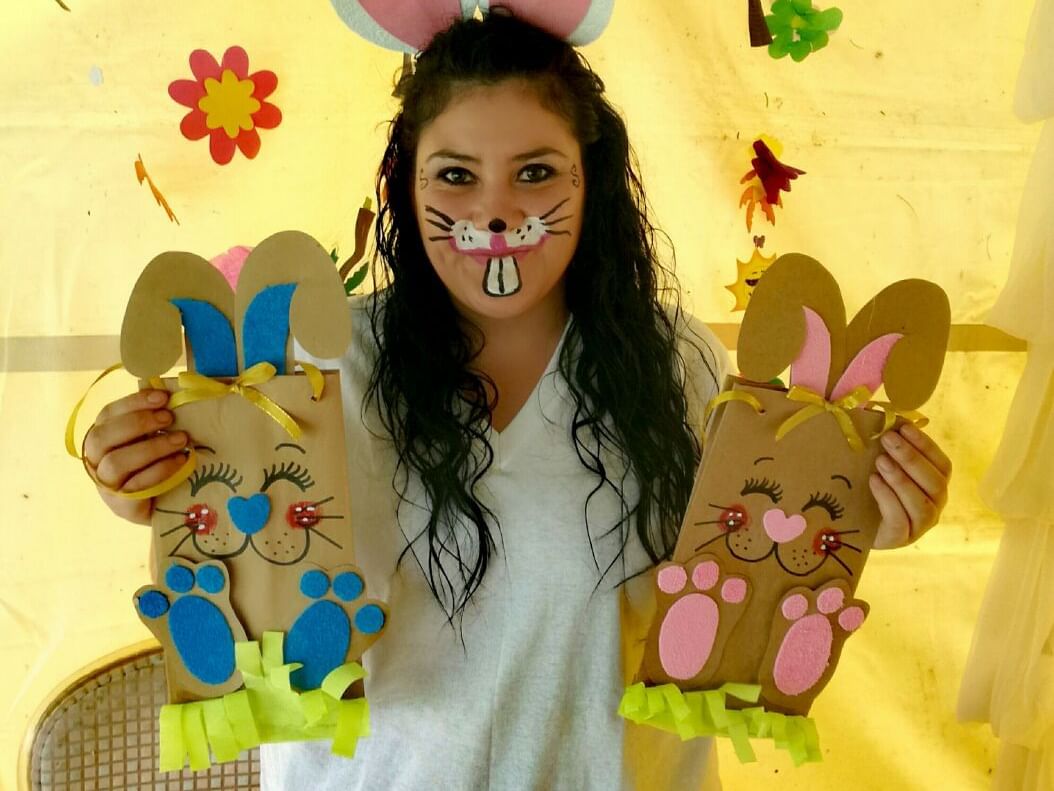 A person holding two colorful paper bunny crafts at Porta Hotel Antigua