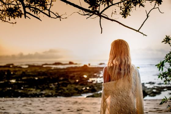 A lady on the beach at sunset near Cala Luna Boutique Hotel