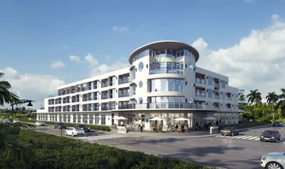 Outdoor cafe with white umbrellas by the curved entrance of Ellipse Grace Bay, best hotels in Turks and Caicos