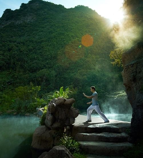 Man doing yoga poses on the deck in Yoga class at The Banjaran Hotsprings Retreat