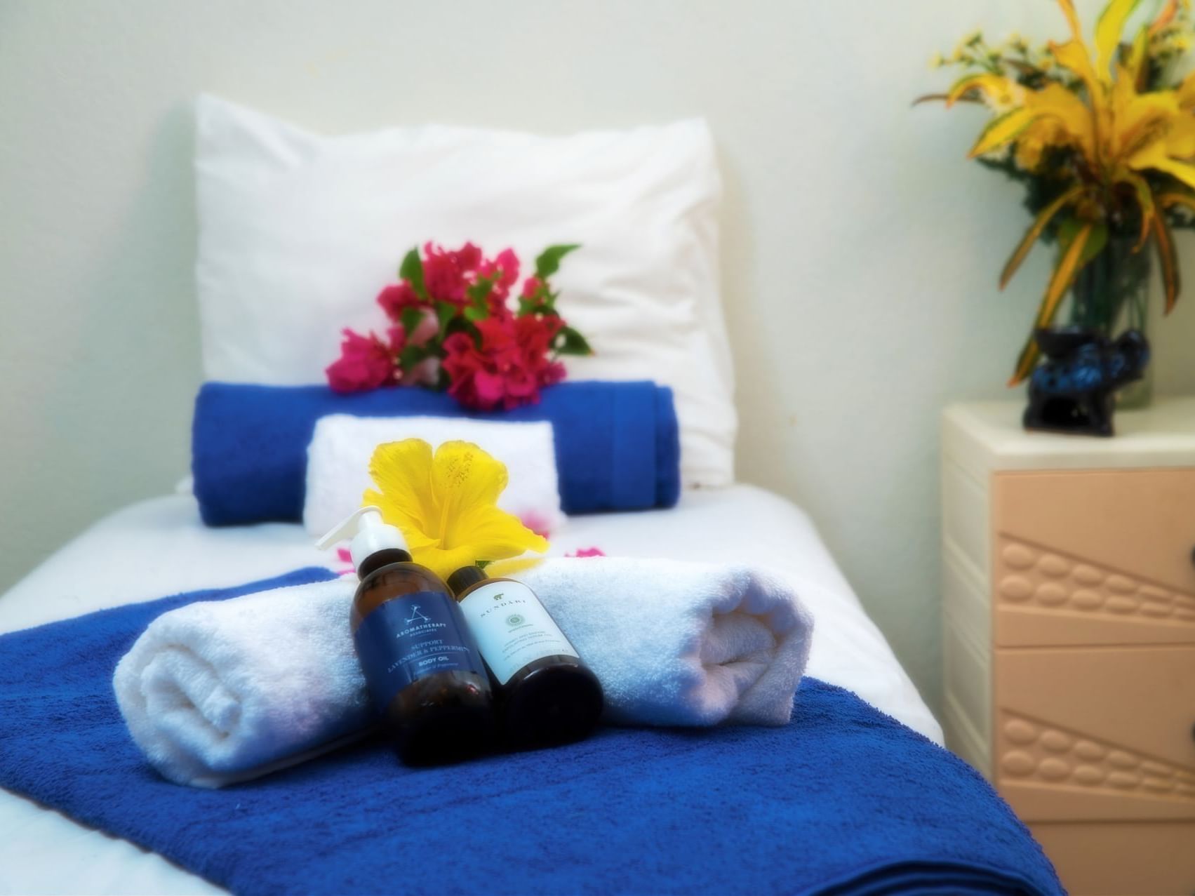 Spa amenities & mini towels with flower décor on spa bed in the Spa at Dover Beach Hotel