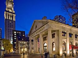 quincy market at night with skyline in background