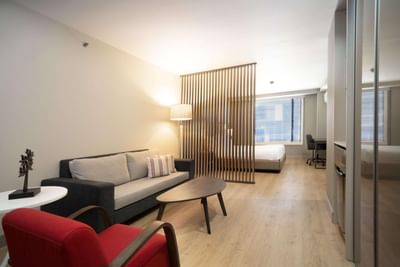 Junior Suite Queen with a lounge area, desk, & a divider for the bed at Habitel Prime Hotel, the best place to stay in Bogota