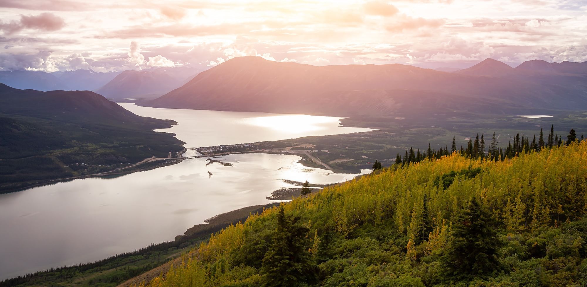 View of the river in the Yukon from a mountain top captured during sunset near Eldorado, a Coast Hotel