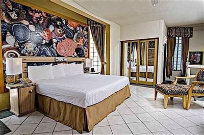 King bed in Ocean View Penthouse Suite with an Artistic Mural at Accra Beach Hotel & Spa