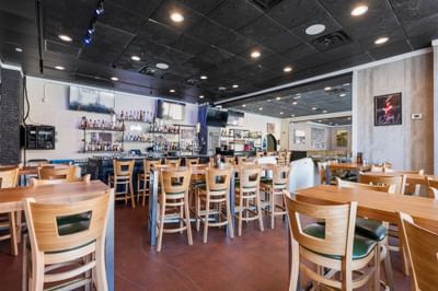 Stylish restaurant interior at The Gavel, The Riverwalk Plaza Hotel, with wooden tables, a stocked bar, and wall decor