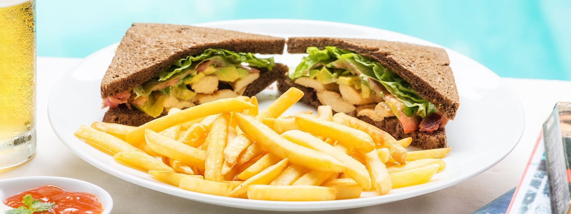 Close-up of sandwiches & fries served in By the Pool at Warwick Melrose Dallas