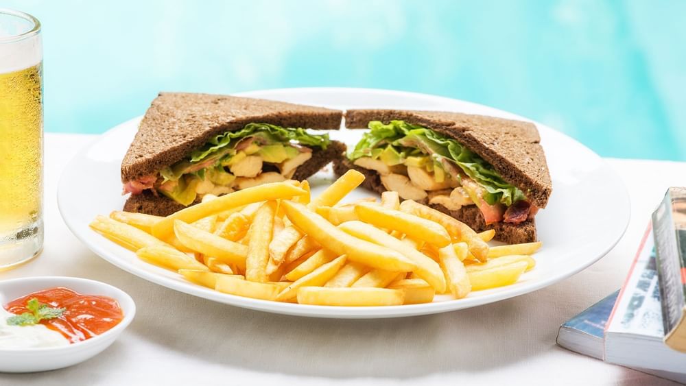 Close-up of sandwiches & fries served in By the Pool at Warwick Melrose Dallas