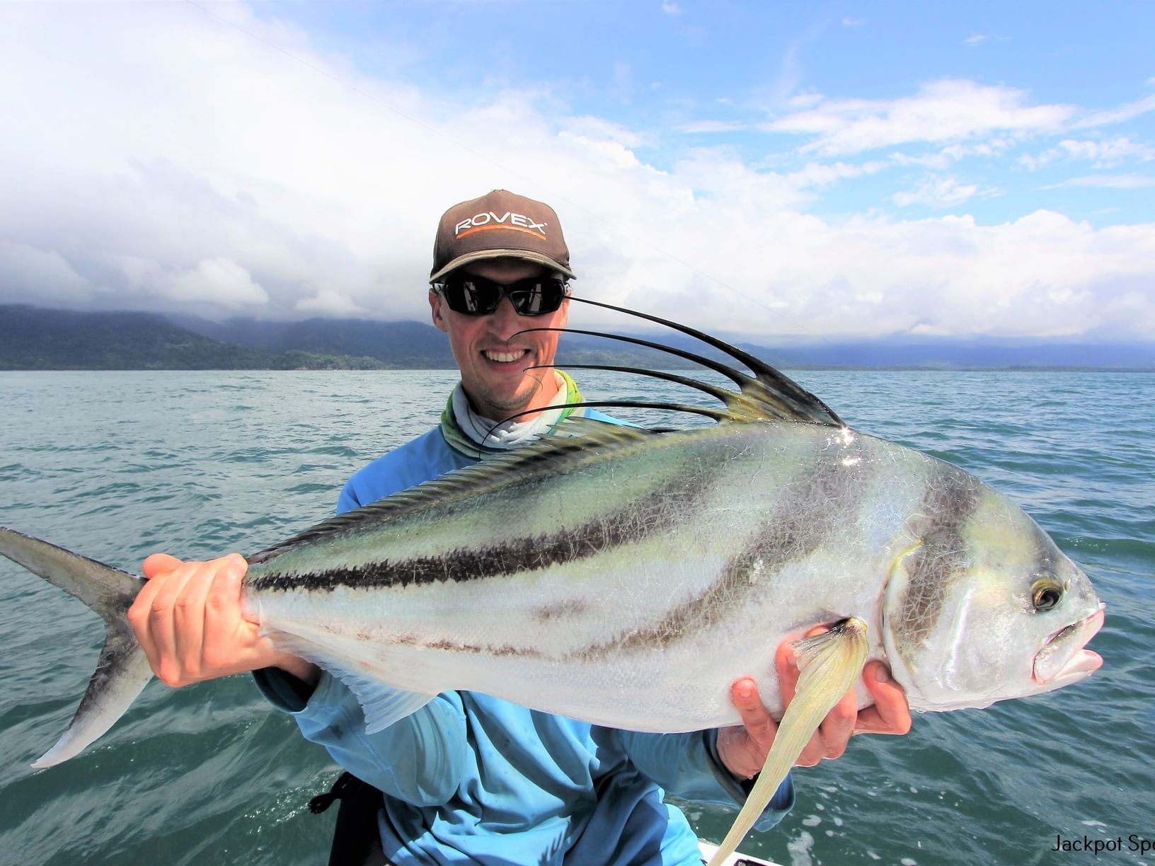 Close-up of a man holding a fish caught in the sea near Jungle Vista Boutique Hotel