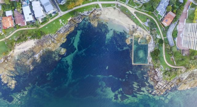 Aerial view of Fairlight Rockpool near Mauad Hotel, featuring a pool by rocks in clear seawater, an elite hotel in Manly