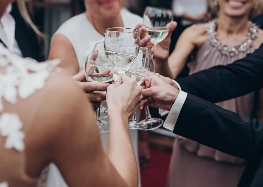Group of people toasting wine glasses in a wedding at The Bethel Resort & Suites