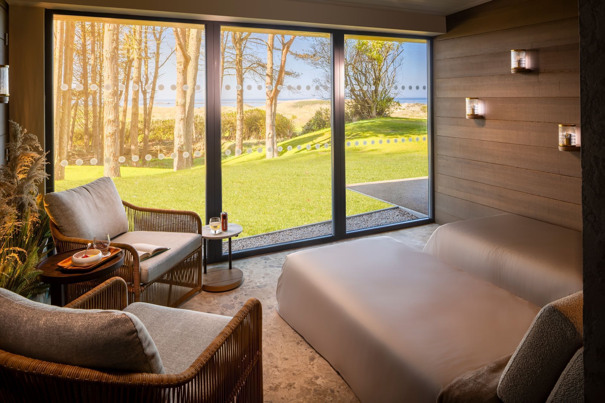 A stunning spa treatment room at Dunluce Lodge, with two day beds and a large window offering beautiful views