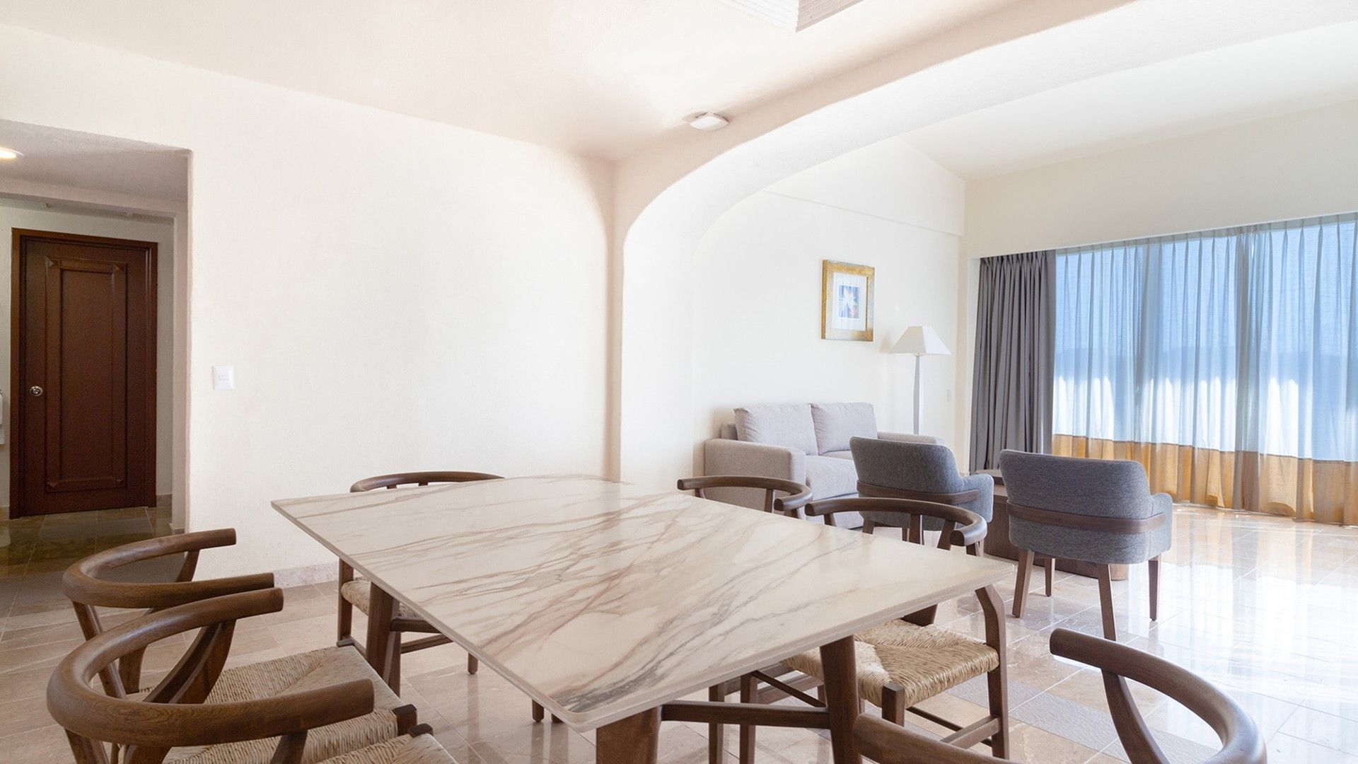 Marble dining table with wooden chairs by the living area in the King Master Suite at Camino Real Acapulco Diamante