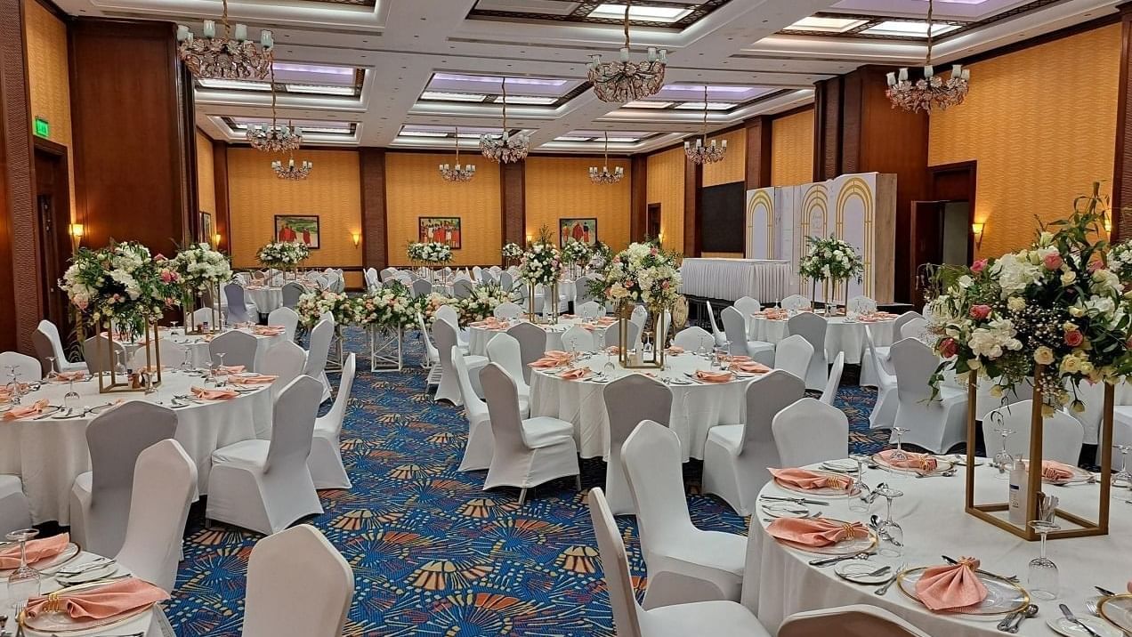 The Ballroom with floral centerpieces and chandeliers for conferences in Africa at Serena Hotels & Resorts