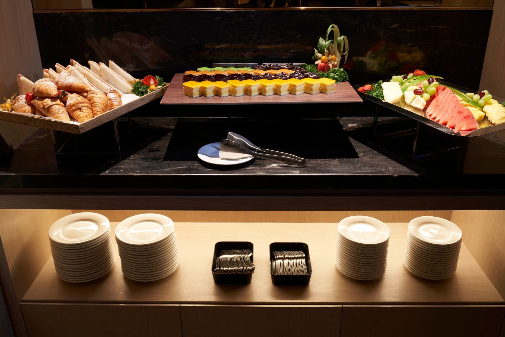 Buffet display with croissants, sandwiches, cakes, fruit and cutlery in a meeting venue at Orchard Grand Court