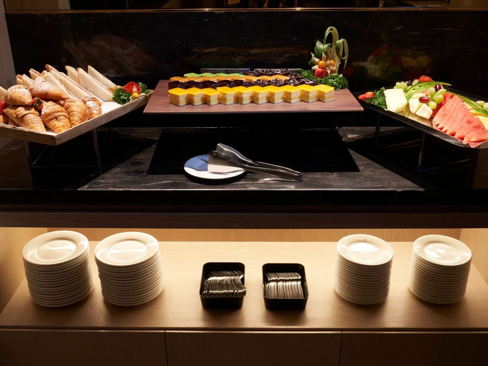Buffet display with croissants, sandwiches, cakes, fruit and cutlery in a meeting venue at Orchard Grand Court