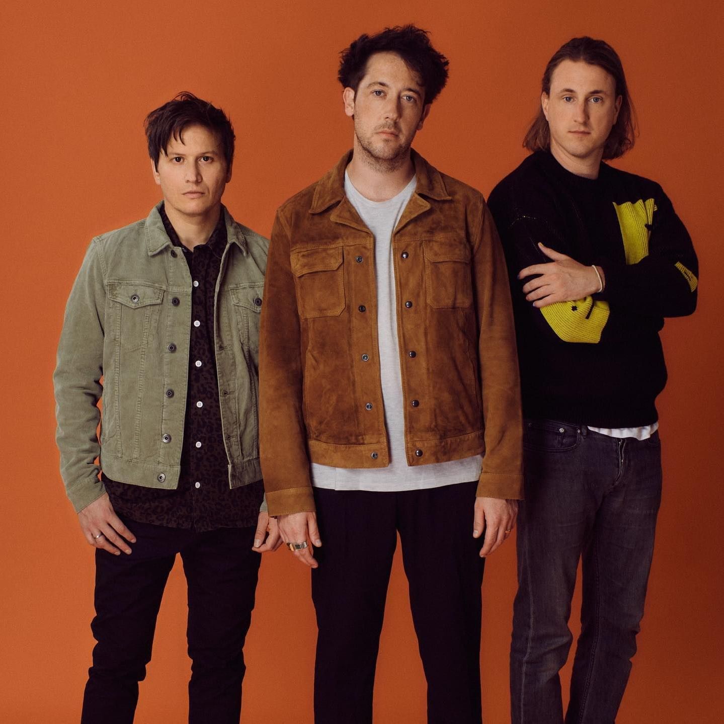 3 men standing staring at the camera