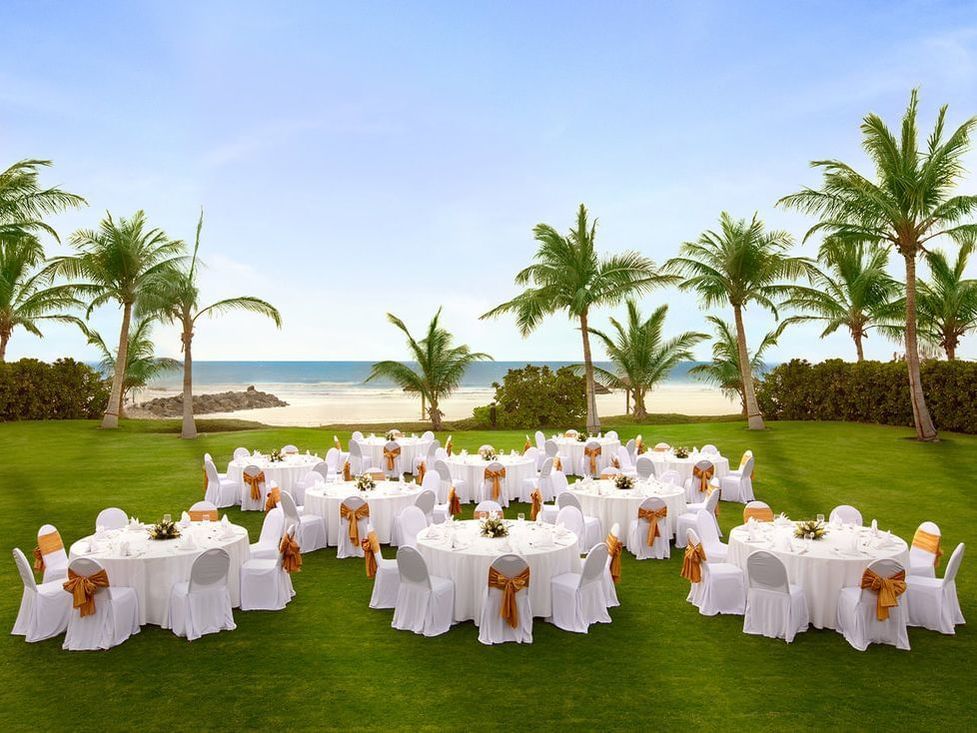 Banquet rounds set up on the Blazon lawn at Ajman Hotel