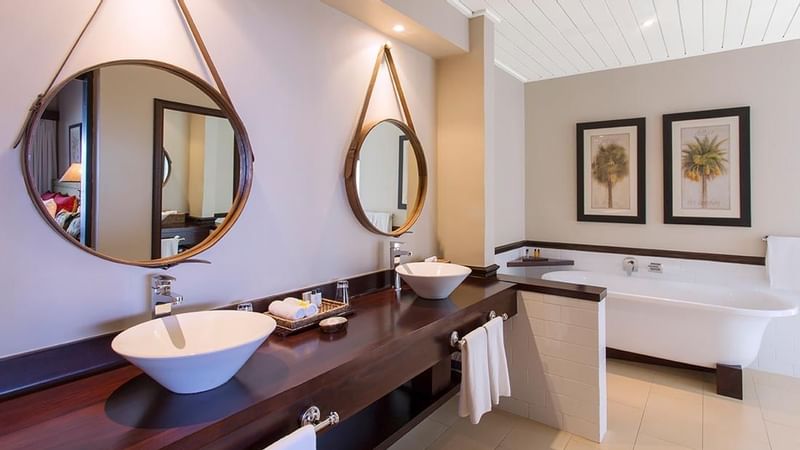 Bathtub with a mirror at Erakor Bathroom at Warwick Le Lagon 