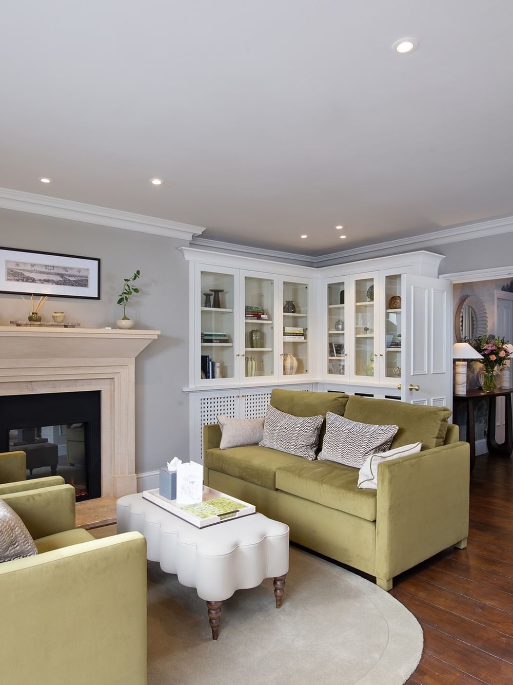 Furnished penthouse living room with green couches and a fireplace at The Capital Hotel, Apartments & Townhouse