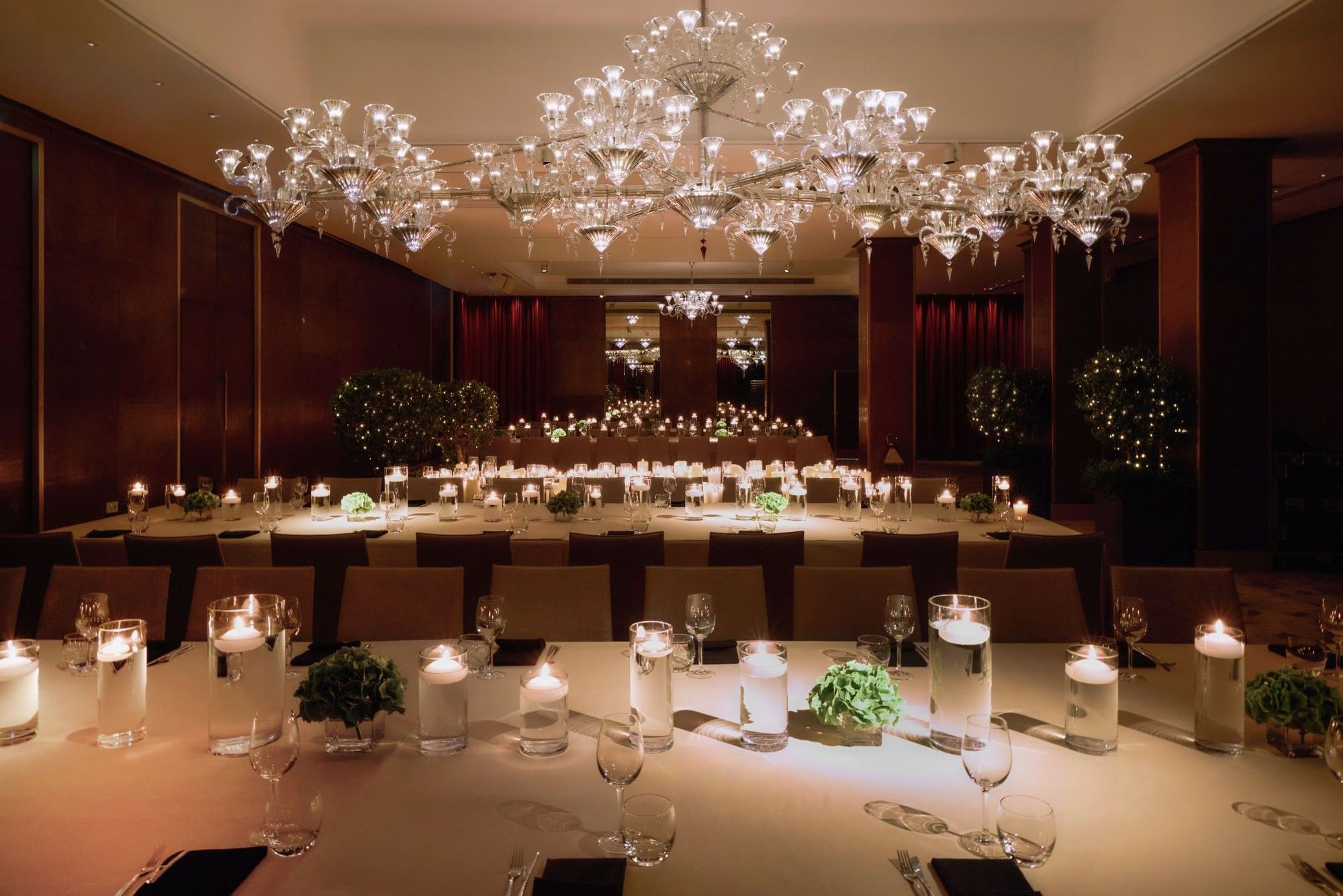 Elegantly set banquet tables under crystal chandeliers at The May Fair Hotel, London.