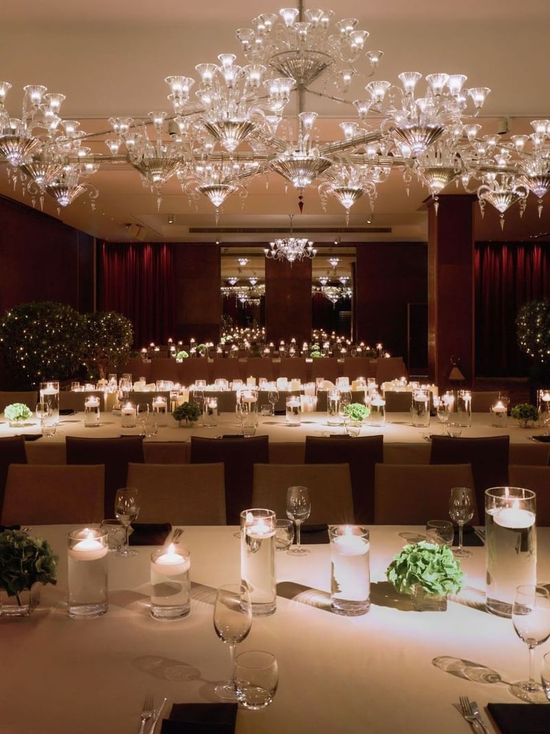 Elegantly set banquet tables under crystal chandeliers at The May Fair Hotel, London.