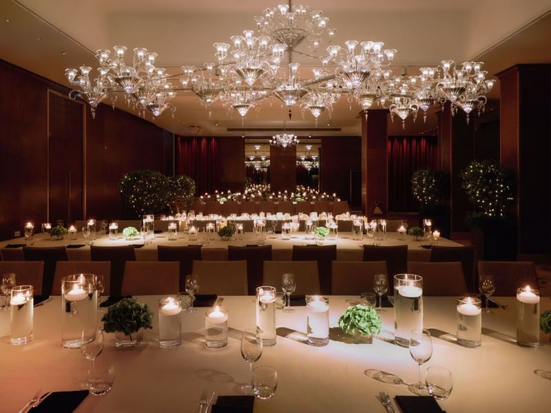 Elegantly set banquet tables under crystal chandeliers at The May Fair Hotel, London.